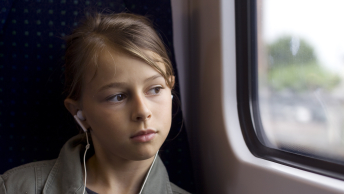 Ung pige ser ud af vindue i tog